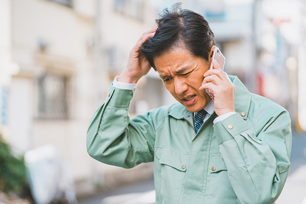 建設業でコミュニケーションがうまくいかずクレームを受ける男性